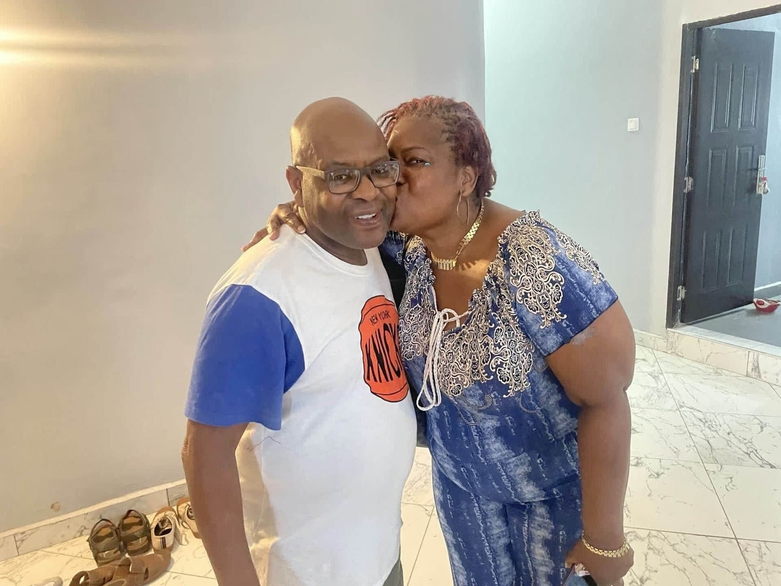 Alex being kissed on the cheek, wearing his Knicks shirt