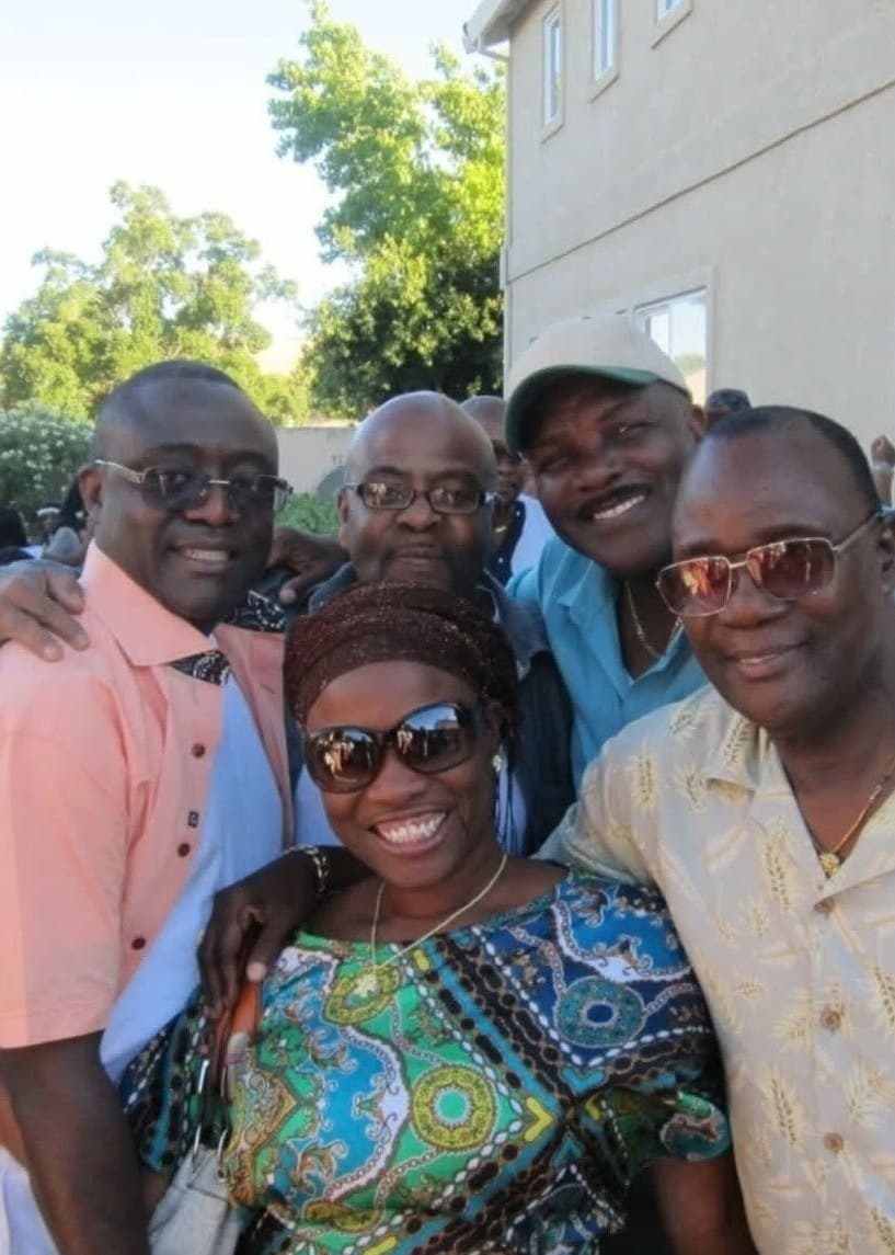 Alex with a group of five friends in African attire outdoors