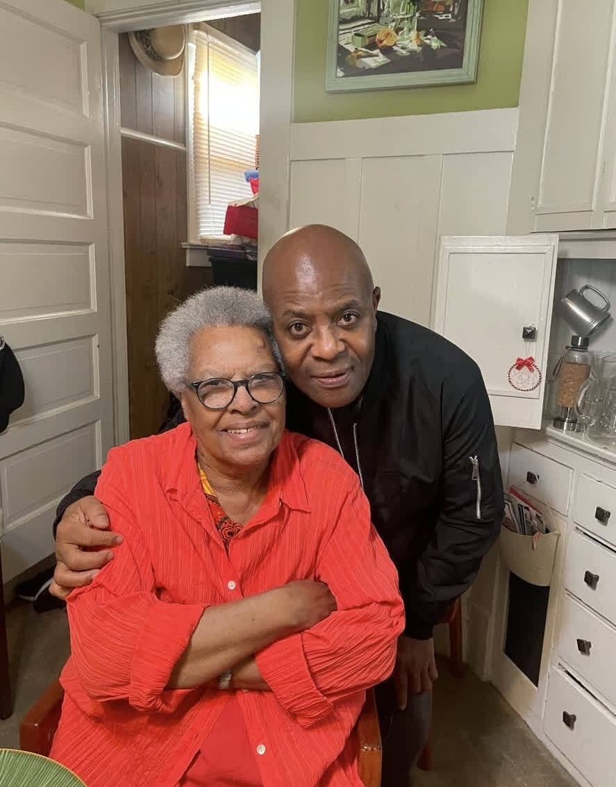 Alex hugging an older woman in the kitchen