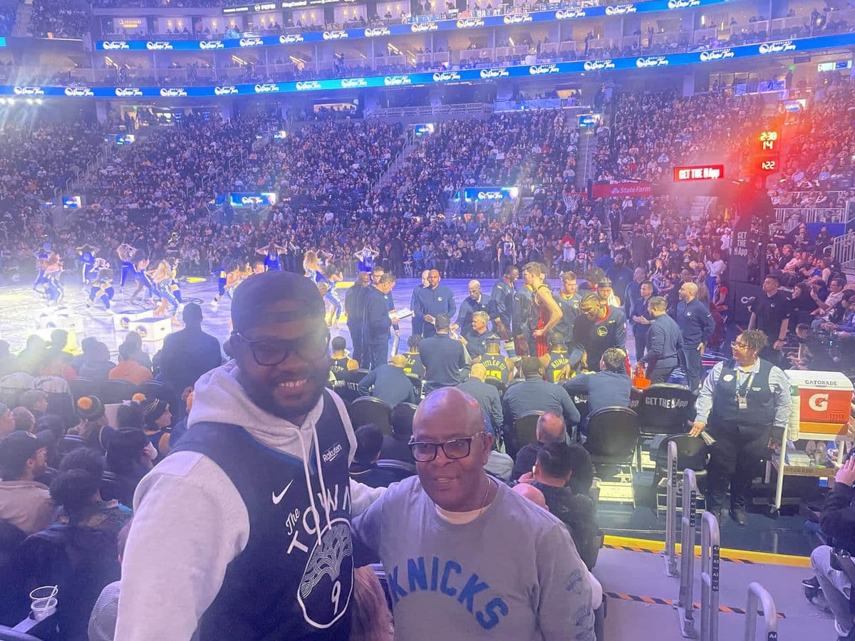 Alex courtside with a friend at a Warriors vs Knicks game