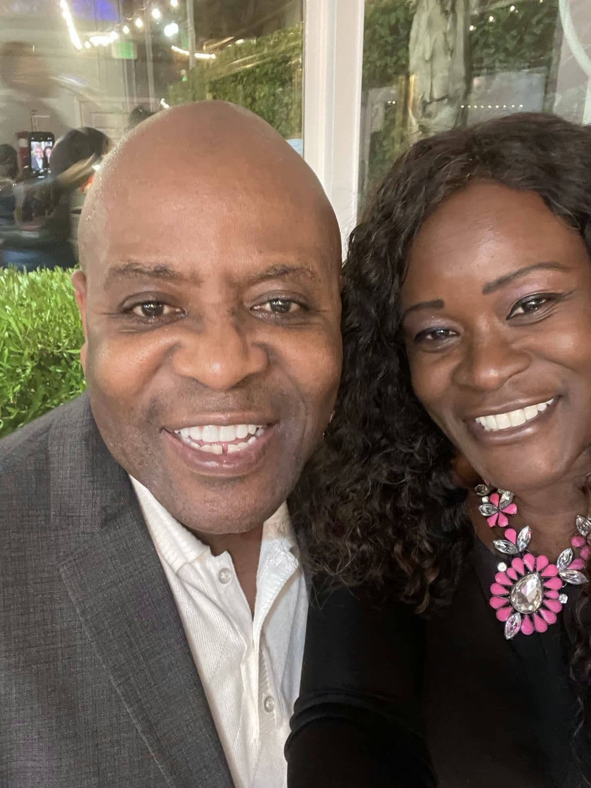 Alex cheek to cheek with a friend at a nice venue