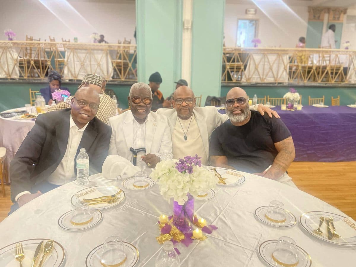 Alex with three friends at a banquet table, dressed to the nines